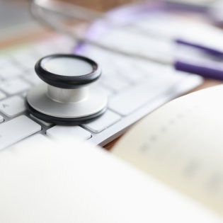 Stethoscope keyboard and diary on the table.